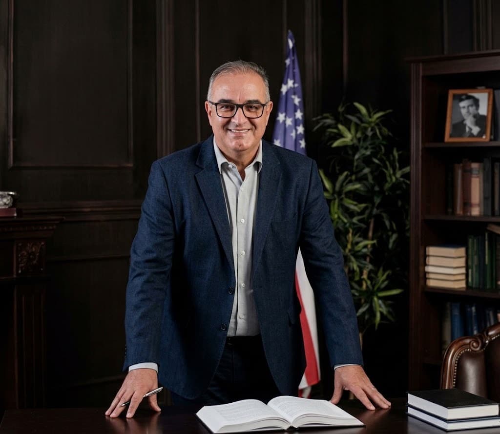 Renato Prone Teixeira da Silva, CEO da E-CONTADOR, em escritório com a bandeira americana ao fundo